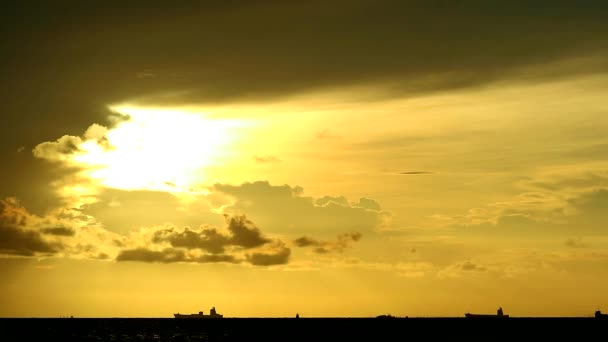 Ouro pôr-do-sol laranja céu amarelo e nuvem vermelha escura se movendo no mar e silhueta estacionamento navio de carga — Vídeo de Stock