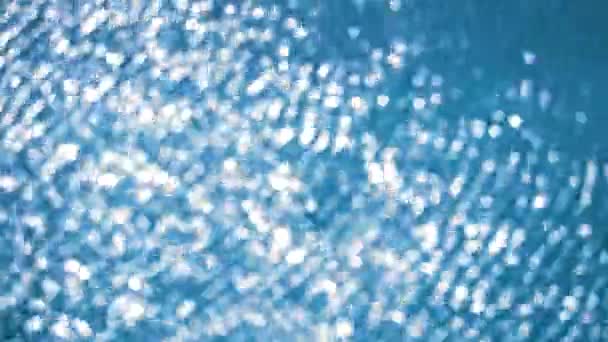 Desenfoque puro claro de agua azul en la superficie de la piscina con reflejos de luz luz solar — Vídeos de Stock