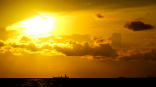 Oro tramonto arancione cielo giallo e rosso scuro nuvola in movimento sul mare e le navi da carico silhouette parcheggio — Video Stock