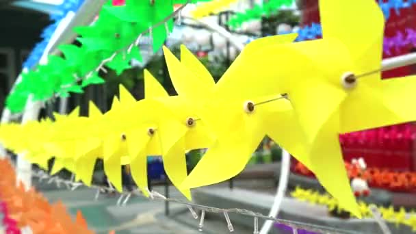 Kleurrijke windmolen speelgoed is ingericht in de voorkant van het winkelcentrum te verwelkomen zomer — Stockvideo