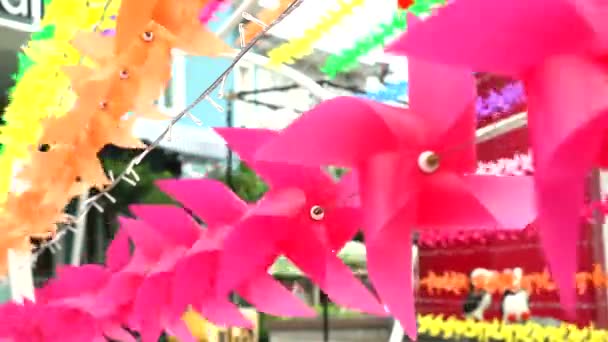 Райдужна іграшка вітряка прикрашена в торговому центрі, щоб вітати літо — стокове відео