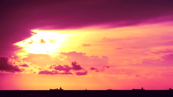 Lila naplemente narancssárga ég és sötét vörös felhő mozog a tengeren és a sziluett teherhajó parkoló — Stock videók