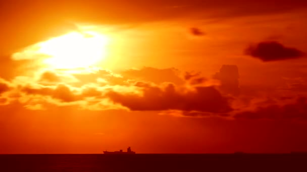 Pôr do sol laranja céu vermelho e nuvem vermelha escura se movendo no mar e silhueta estacionamento navio de carga — Vídeo de Stock