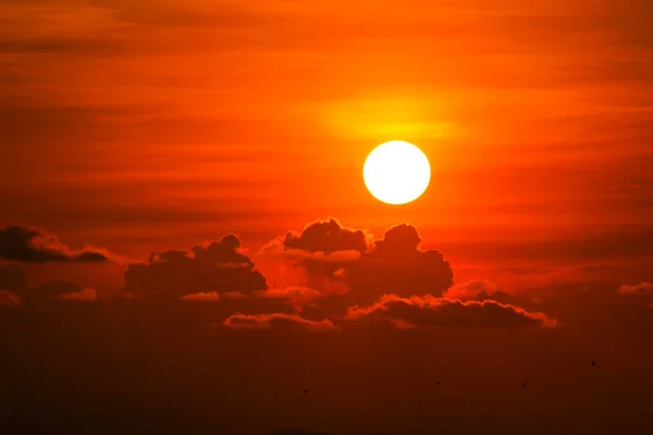 Pestrá hromádka červeného oranžového mraku a slunce na obloze — Stock fotografie