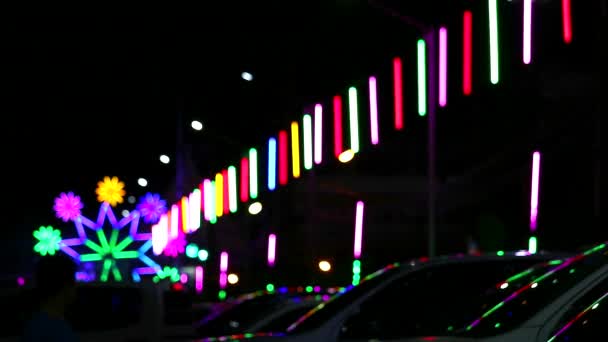 Sfocatura neon luce rotolamento e silhouette auto nel mercato notturno fiera parcheggio — Video Stock