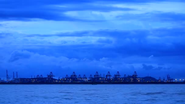 Grúa de puerto marítimo en movimiento de carga y contenedor y nube azul oscuro pasando — Vídeo de stock