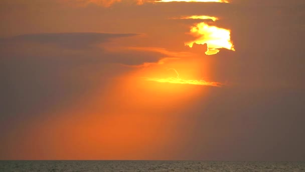 Puesta de sol y rayos de sol de nuevo en el cielo naranja nube sobre el mar — Vídeo de stock