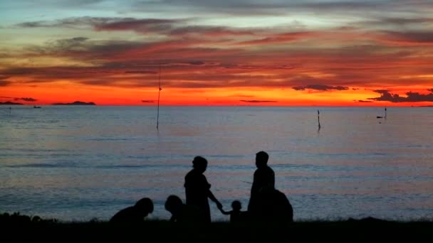 Familie neem foto zonsondergang op zee en lopen op het strand — Stockvideo