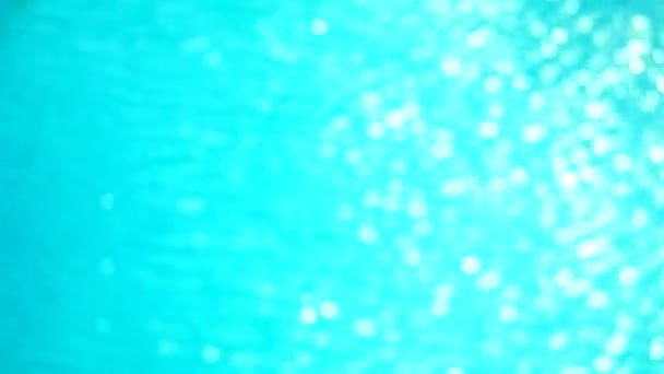 Flou peu pure couleur bleue claire de l'eau à la surface de la piscine avec des reflets de lumière lumière du soleil — Video