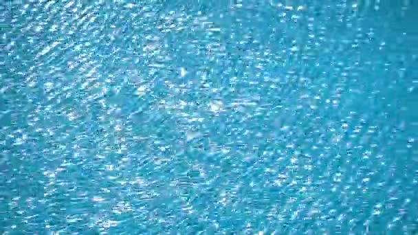 Zuiver helder blauw water in zwembad oppervlak met lichtreflecties zonlicht — Stockvideo