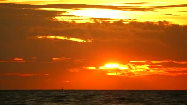 Sonnenuntergang orange-roter Himmel und dunkelrote Wolken, die sich im Zeitraffer über das Meer bewegen — Stockvideo