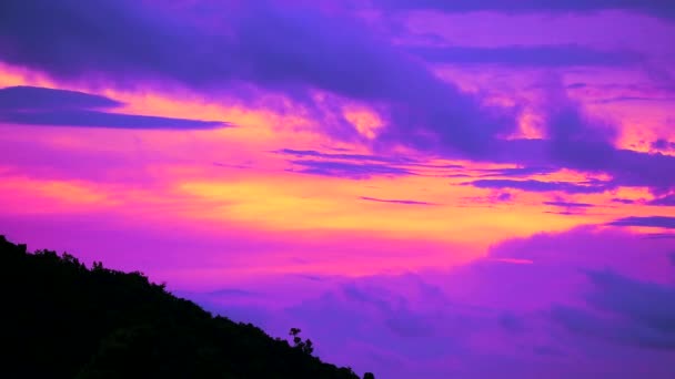 Захід сонця небо з фіолетовим хмарним ходом проходить зелений верхній силует гори 1 — стокове відео