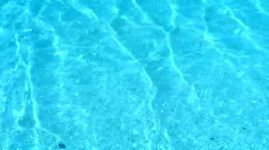 Deniz yüzeyindeki su, ışık yansımaları ve dalga dalgalarıyla berrak.