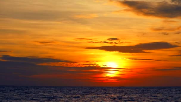 Coucher de soleil ciel orange et nuage rouge se déplaçant et vague sur la mer — Video