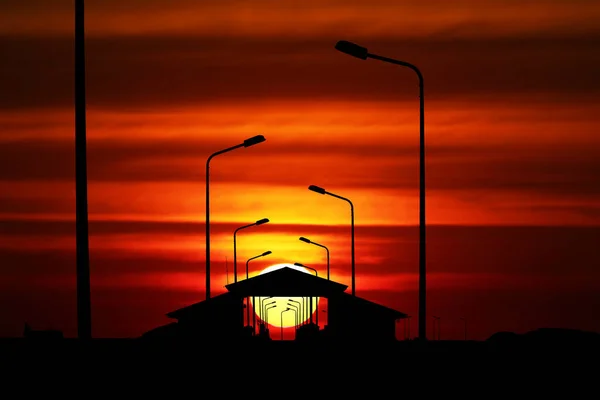 夕阳西下色彩斑斓的天空 码头亭子上的红云和轮廓光柱 — 图库照片