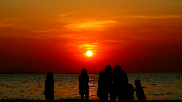 Silhueta amigo na praia tirar foto do pôr do sol no mar — Vídeo de Stock