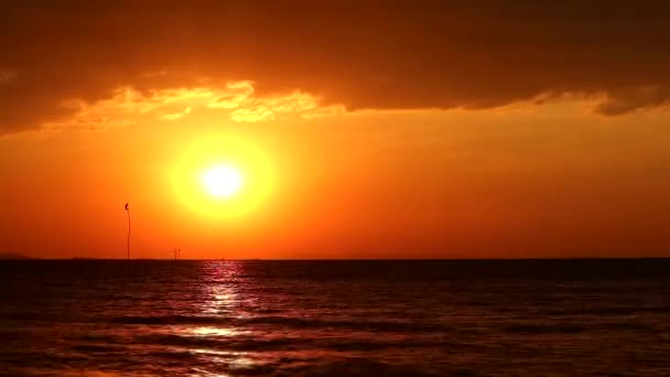 Sonnenuntergang auf dem Meer und Silhouette Flagge schwingen durch Wind — Stockvideo