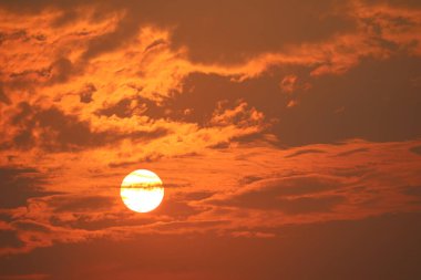 Güzel gün batımı turuncu sarı ve koyu kırmızı gökyüzü alevi bulutlara geri döndü