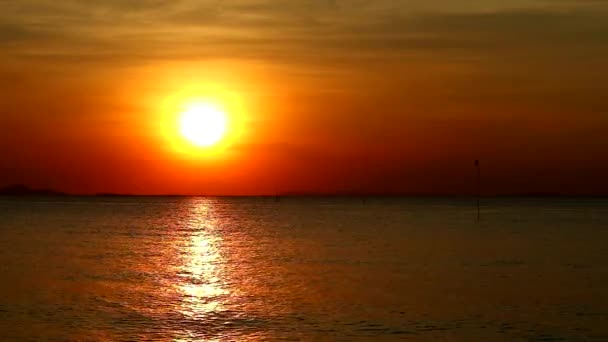 Ηλιοβασίλεμα στο σκοτεινό ουρανό και αντανάκλαση του ήλιου με λίγα στην επιφάνεια της θάλασσας — Αρχείο Βίντεο