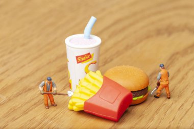 Sağlıksız beslenme kavramı ile kaybetmek minyatür insanlar ve fast food