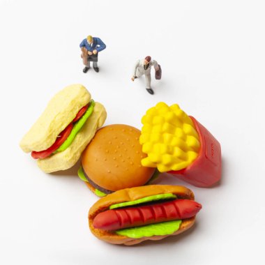 Sağlıksız beslenme kavramı ile kaybetmek minyatür insanlar ve fast food.