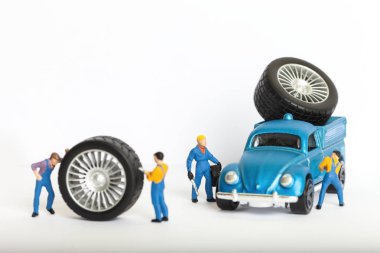 Atölye lastik uydurma kavramı. Tozlu oyuncak araba tekerleği, tamir minyatür mekaniği yakın çekim.