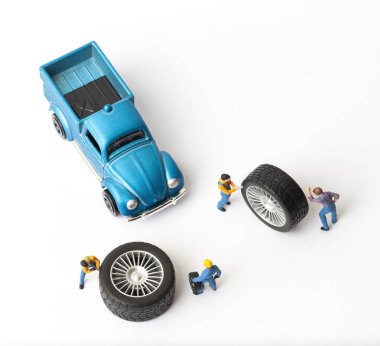 Atölye lastik uydurma kavramı. Tozlu oyuncak araba tekerleği, tamir minyatür mekaniği yakın çekim.