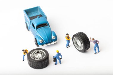 Atölye lastik uydurma kavramı. Tozlu oyuncak araba tekerleği, tamir minyatür mekaniği yakın çekim.