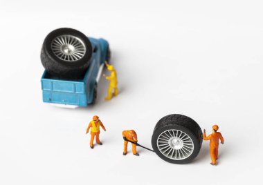 Atölye lastik uydurma kavramı. Tozlu oyuncak araba tekerleği, tamir minyatür mekaniği yakın çekim.