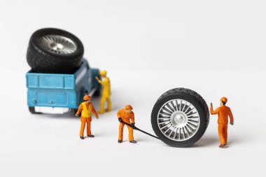 Atölye lastik uydurma kavramı. Tozlu oyuncak araba tekerleği, tamir minyatür mekaniği yakın çekim.