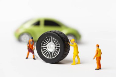 Atölye lastik uydurma kavramı. Tozlu oyuncak araba tekerleği, tamir minyatür mekaniği yakın çekim.