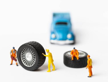 Atölye lastik uydurma kavramı. Tozlu oyuncak araba tekerleği, tamir minyatür mekaniği yakın çekim.