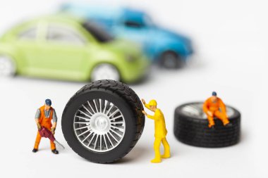 Atölye lastik uydurma kavramı. Tozlu oyuncak araba tekerleği, tamir minyatür mekaniği yakın çekim.