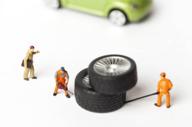 Atölye lastik uydurma kavramı. Tozlu oyuncak araba tekerleği, tamir minyatür mekaniği yakın çekim.