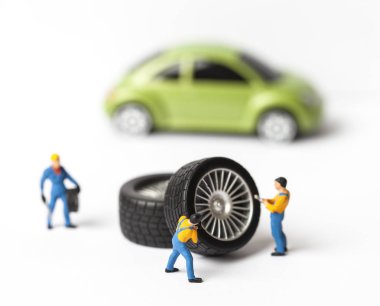 Atölye lastik uydurma kavramı. Tozlu oyuncak araba tekerleği, tamir minyatür mekaniği yakın çekim.