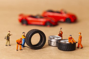 Atölye lastik uydurma kavramı. Tozlu oyuncak araba tekerleği, tamir minyatür mekaniği yakın çekim.