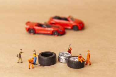 Atölye lastik uydurma kavramı. Tozlu oyuncak araba tekerleği, tamir minyatür mekaniği yakın çekim.