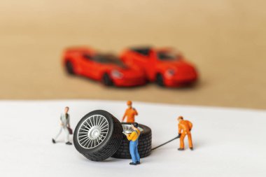 Atölye lastik uydurma kavramı. Tozlu oyuncak araba tekerleği, tamir minyatür mekaniği yakın çekim.