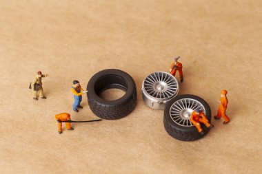 Atölye lastik uydurma kavramı. Tozlu oyuncak araba tekerleği, tamir minyatür mekaniği yakın çekim.