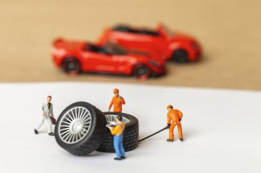 Atölye lastik uydurma kavramı. Tozlu oyuncak araba tekerleği, tamir minyatür mekaniği yakın çekim.