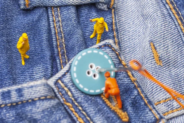 Concept Fashion Industry Miniature Workers Sew Buttons Big Needle Jeans — Stock Photo, Image