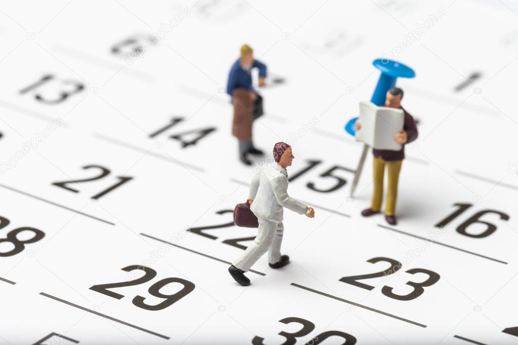miniature people on calendar background