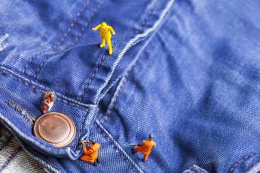 Moda endüstrisi için kavram. Minyatür işçi denim doku. Yakın çekim.
