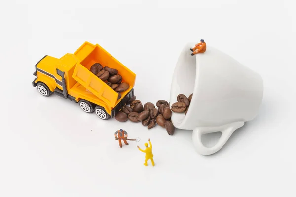 Miniature workers unload coffee beans. Coffee time concept.