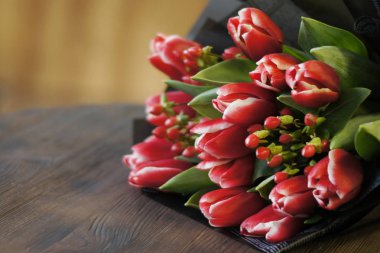 Bahar çiçekleri. Kahverengi ahşap zemin üzerinde kırmızı lale buketi. Anneler günü, Sevgililer günü, Womans gün arka plan kopya alanı ile.