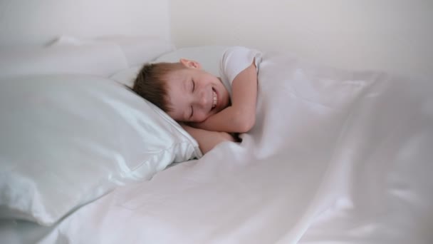 Zeven Jaar Oude Jongen Net Wakker Lacht Terwijl Liggend Bed — Stockvideo