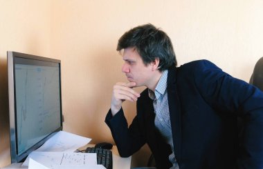 Genç adam bilgisayar başında çok çalışıyor