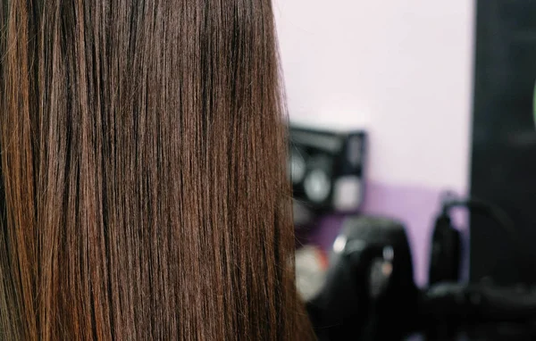Long brunette hairs closeup in barbershop. — Stock Photo, Image