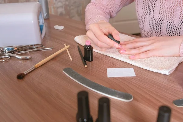 Kvinnan sätter första lager rosa shellack på sina naglar. Närbild. — Stockfoto