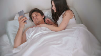 Adam bir şey telefon ve kadın bakan bu pats ve yüzünü ona döner.